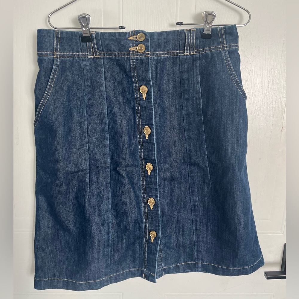 Jean skirt with buttons that go all the way down. Two pockets on the side.